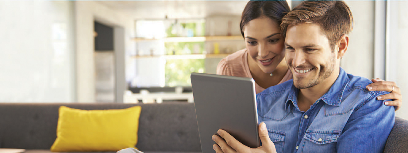 couple looking at tablet on couch